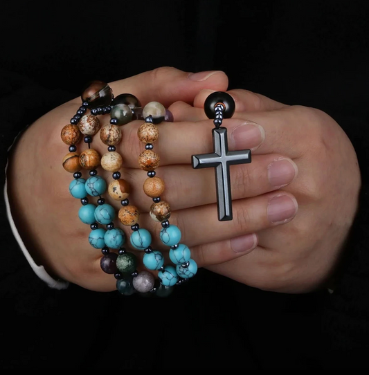 Rosário com contas de hematita e cruz decorativa.